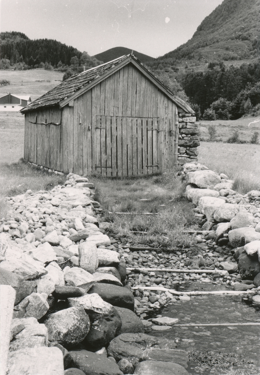 Dokumentasjonsbilder i serie av et naust ved Syvdsfjorden, mellom Eidså og Koparnes. Naustet har en steinvegg mot den mest værharde retninga.