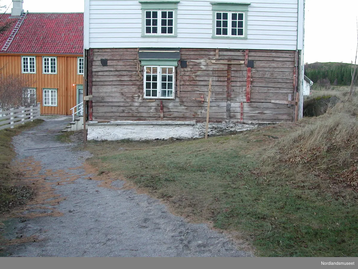 Østveggen på Krambua under restaurering. Noe panel er tatt ned. Hovedbygninga i bakgr.