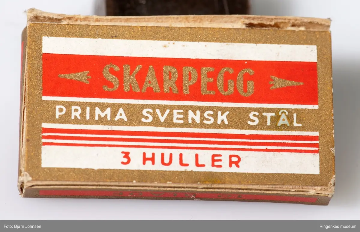 På eskens front: smal ramme og parallelle lodrette linjer på venstre side. På to sideflater - ANT stilisert barberhøvel