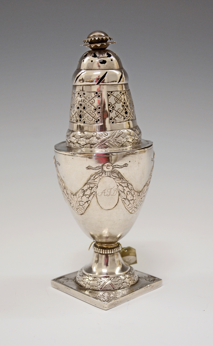 Fra protokollen: Sukkerdrysse av sølv, urne form, Ludvig 16. stil. Stemplet synes at være Kristiansands bystempel.

Oppført som sukkerdrysse i protokollen, men kan det være en "sanddrysse" - for fjerning av overflødig blekk ved bruk av fjærpenn og blekk?