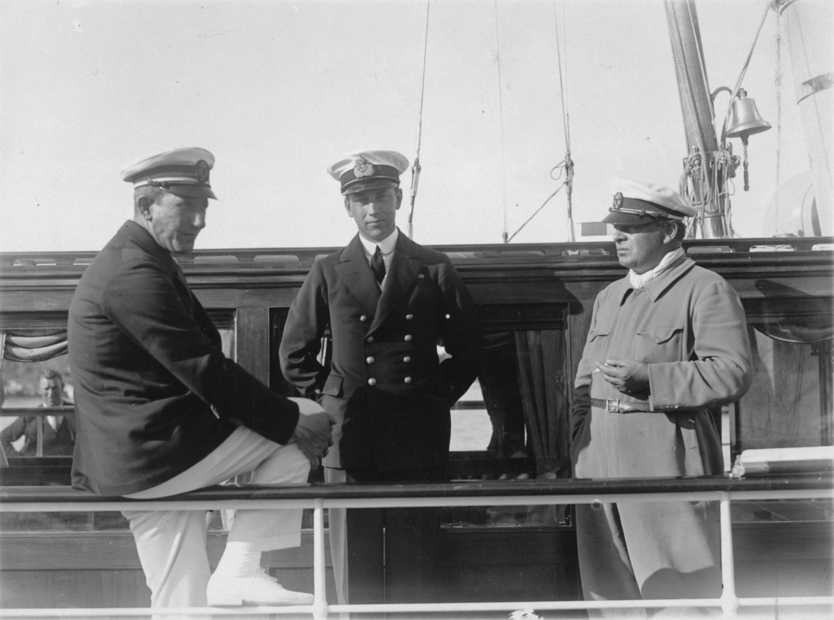 De båda männen t v är, liksom båten, oidentifierade. T h ses med cigarett och KSSS-mössa Evert Taube.