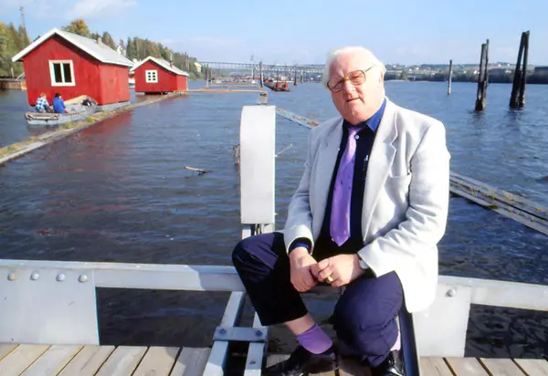 Foto av person som sitter ute på en konstruksjon på elva.