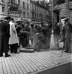 Ett par gatuarbetare som åtgärdar någonting i hörnet av Stor