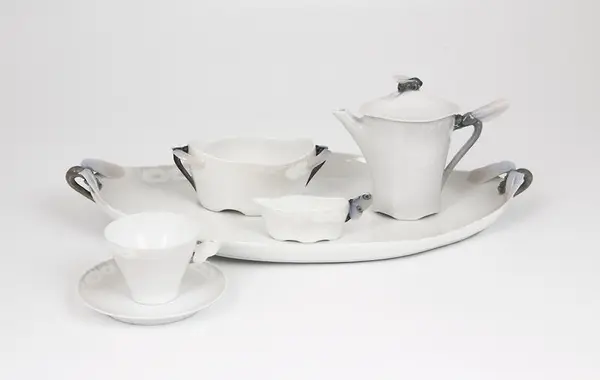 Støpt kaffeserviset i glasert porselen. Servisets overflate er hvitfarget, men enkelte partier er malt i gråfiolette fargetoner. Håndtakene er vekslende utformet som libeller, bier og sommerfulger. På flere av servisets deler er det fremstilt margeritter i lavt relieff.