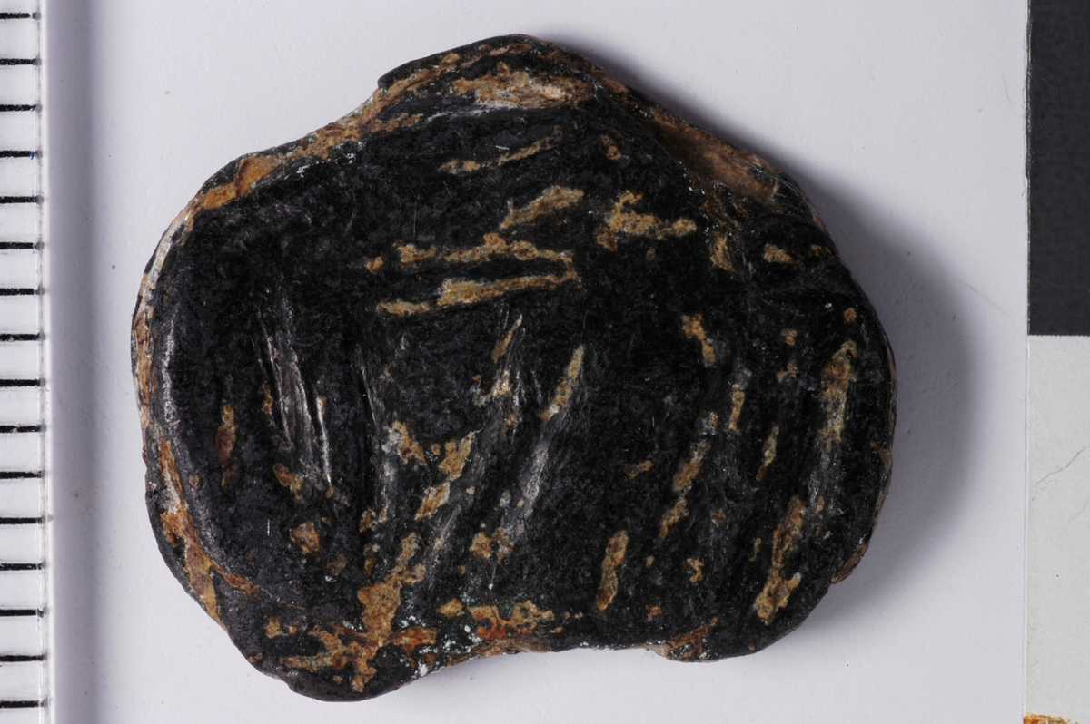 Begge sider viser Konturer av et våpenskjold. den ene siden viser et mulig skrått bånd fra øverst til venstre og ned til høyre som deler skjoldet. den samme plaketten har svake antydninger til kroppen av et stående fabeldyr til høyre for skjoldet. 