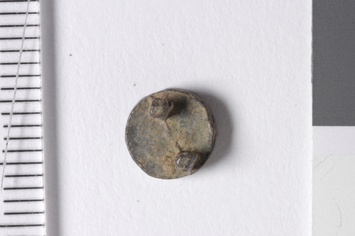 MALV: DIAM. 7 MM, SIRKULÆR PLATE MED KONVEKS OVERSIDE, TO TOPPER PÅUNDRSIDEN. PÅ GAMLE KATET STÅR 02. 536364 HELLE !