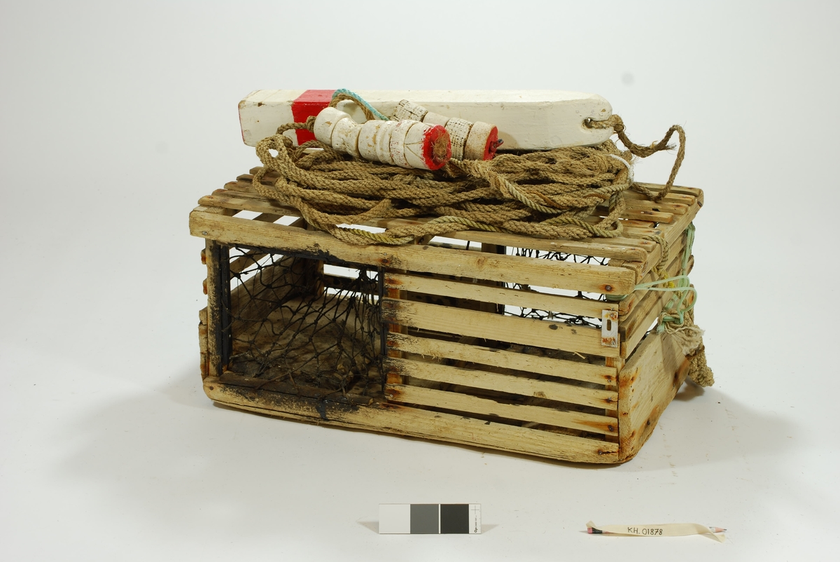 Typisk eksempel på kasse-tene, hvor original fiskekasse er benyttet som fangstfelle. Kort og kompakt kasse med bunn av gammel utrangert fiskekasse. Horisontale lekter overfor selve kassebordene. Grovt hjemmelaget garn av nylontau med tverrknuter - et sjeldent fenomen! 
En inngang på hver langside. Ingen fangstkammer. 
Agnpinne av grov metalltråd. 

Kalven: Et tynnere tau er festet til garnet i kalven tversgående, før å gjøre maskene mindre. Kalvene er impregnert med tjære, trolig for å gjøre tauet mørkt slik at hummeren går inn. Kalvene er festet til åpningen med en lekte. Garnet festet rundt en lekte som deretter er spikret fast i tena. Metallringer i kalveåpningene. 

Lokk av to lekter. Lukkeåpning; moderne skyvepatent med vrider. Skyvemekanisme; skyves bort og vippes opp. 
En liten metallplate er festet vertikalt over to lekter, - uvisst hvorfor. Støpt betonghelle i hver ende, dekker hele bredden. E.V. risset inn i den ene. 

Komplett tauverk med væler. Tau i naturfiber. Festet til tena med syntetisk tau. Ekstra tau flettet inn i nederste del for å gi tauet flytekapasitet. 
Væle: malt hvit med en rød stripe ca. 10 cm fra bunnen. Bunnplata malt rød. E.V. skåret inn i treverket på det hvite feltet. Spiss ende med hull til tau. 
Tolver og sekser væler: 1) 4 korkbiter. Festet til tauet med blått syntetisk tau. Malt helt hvit, men rød i bunnen. 2) 6 korkbiter. Hvitmalte, rød i enden. Festet til tau med tau i naturfiber.