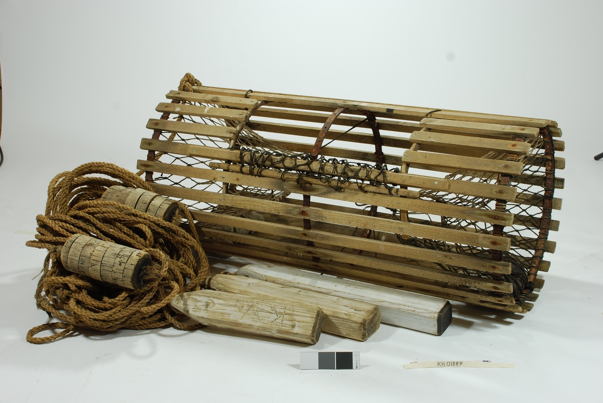 Rund/ sylindrisk sprøtt-tene. Hjemmespunnet garn med store masker. To motstående innganger i kortsidene. Intet fangstkammer. Kalveringer i metall, ovale i formen tilpasset krabbens fasong. Ovalformet åpning i toppen forsterket med ubehandlede barkkledde enerkvister som er formet til. Metallgjorder virker solide og kan være spesiallaget. Agnspyd i metall horisontalt plassert med ekstra sperre i kalveringen. Synkestener i granitt i hver ende, bundet fast med sort tauverk. Åpning med gammeldags lukkepatent med garn og håndspikket pinne. Tena bærer preg av tidligere å ha vært tjæret/ barket. 

Store mengder gresstau og fem væler, tre stk. i treverk og to stk. av kork. 
Hvitmalte trevæler i tre størrelser:
Størst: 63x9 cm.
Mellomst: 51x9 cm. 
Minst: 41x9 cm.
Alle har profilerte kanter og er hvitmalte med sort ende (tjæret). Malingen er nesten slitt av. K.V er skåret inn i de tre fløtene.
Korkvæler:
Lengde: 22cm
Omkrets 32 cm.
K.V risset inn i den ene.