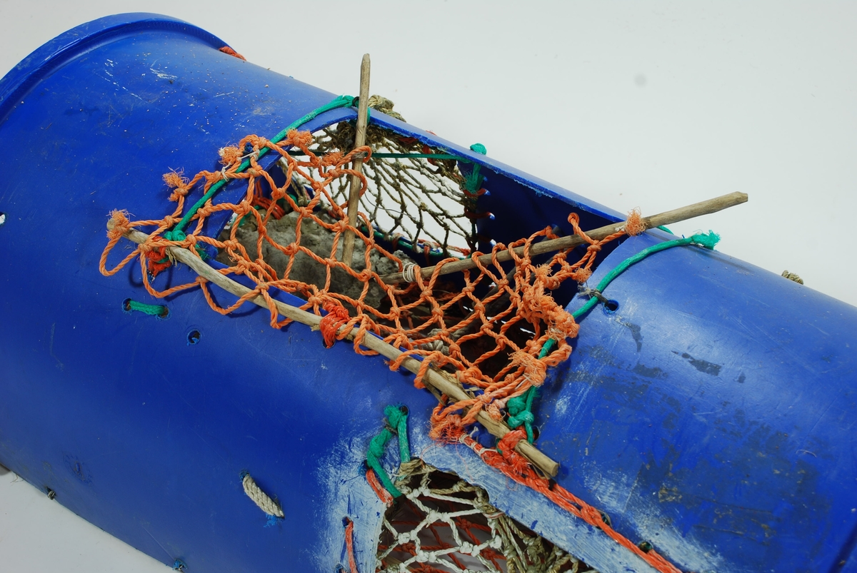 Tønnetene med to innganger på kortsidene. En stor blå hård-plast tønne delt i to vertikalt, samt fått ny åpning kravialt. Langsgående furulekter i bunnen. Meget robust konstruksjon. Garn av trålnot av nylon. Lukkeåpning med garn og heftepinne av energren. Agnen festes med tverrgående nylontråder med knute/ stramme funksjon. Ingen tau eller væler.