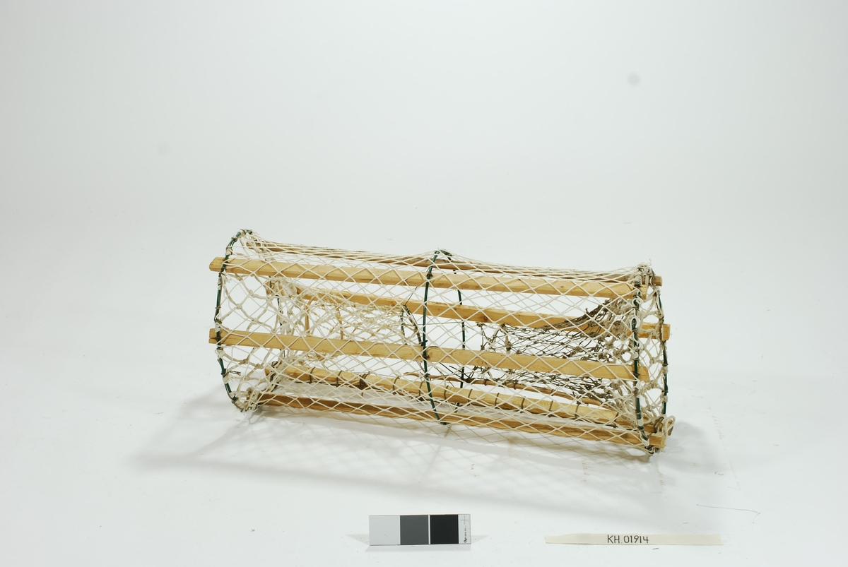 Laget som leke til barn. Sylindrisk sprøtt-tene med to motstående innganger. Seks grove spiler i forskjellige trematerialer. Tre gjorderinger i metall. Intet fangstkammer. Kalveringer i vidjebånd og metall. Ulikge garntyper i syntetisk materiale, store maskehull. Ingen synkestener, tau eller væler. Gammeldags lukkeåpning med håndskåret pinne.