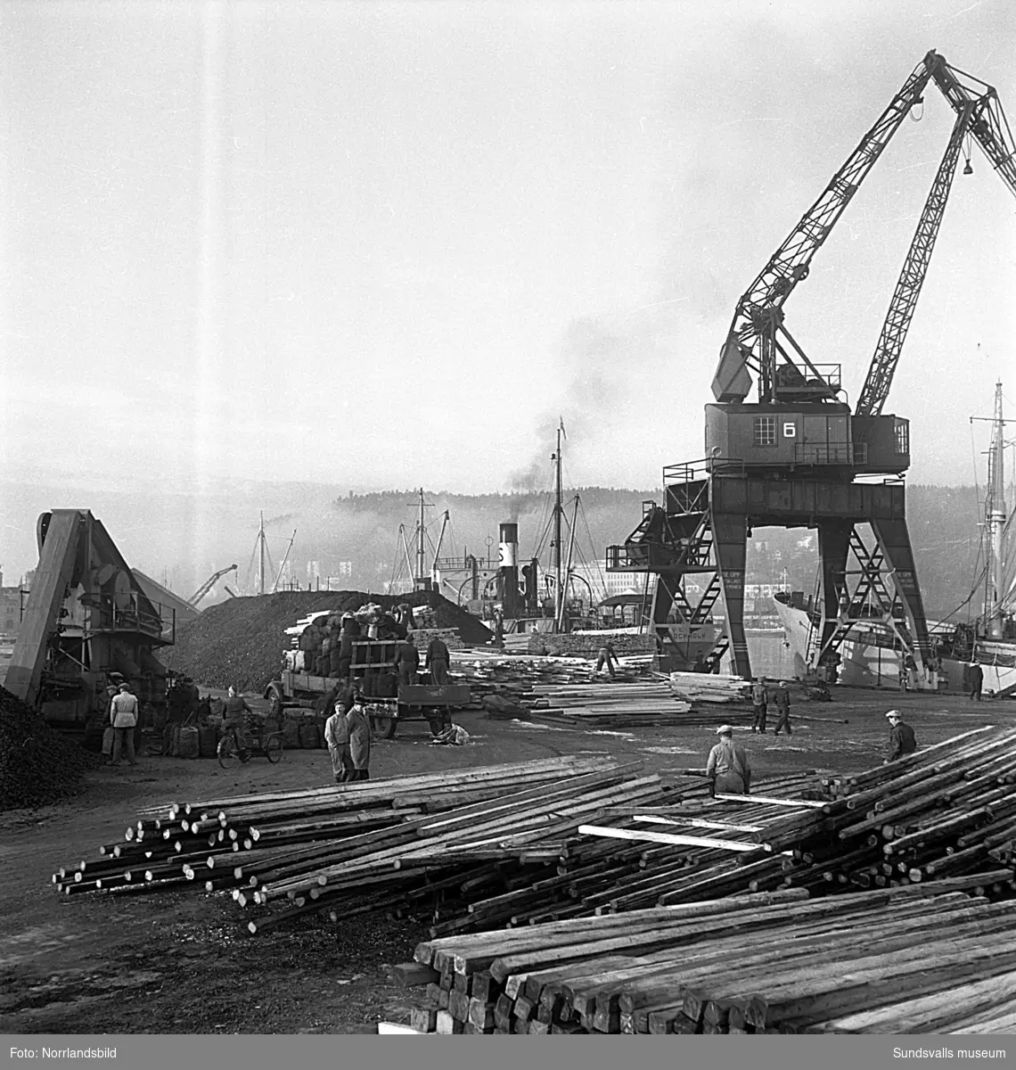 En serie bilder från verksamheten i hamnen i början av 1950-talet. Båtar, pråmar, kranar, kolhögar och magasin.