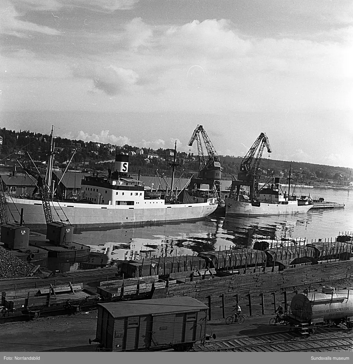 En serie bilder från verksamheten i hamnen i början av 1950-talet. Båtar, pråmar, kranar, kolhögar och magasin.