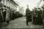 Järnvägsgatan (Rantavägen) med stadshotellet, förut Jouvins hotell t.v. under manövern 1912. Mannen som syns mot den första flaggstången i gatan är bokhållaren Otto Rehn på bryggeriet Victoria.