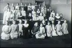 1:a klass i Falköpings folkskola år 1912, 42 elever. Lärarinna: Lisa Hansson. Eleverna födda 1902-1903. Första raden till vänster: 1. Tyra Karlsson, 2. Ellen Pettersson (Göteborg), 3. Karin Kjellin? 4. Märta Värn?, 5. Stina Hansson, 6. Svea Käck (Linnarsson), 7. Anne-Marie Wallenberg, 8. Greta Grönlund. Andra raden från vänster: 1. Hilma Moberg (USA), 2. Helga Johansson, 3. Carin Högberg, 4. Anne-Marie Appelkvist?, 5. Karin Gustavsson, 6. Anna Jofur, 7. Sara Hedberg, 8. ?9. Greta Ljungkvist, 10. ? Tredje raden från vänster: 1. Tyra Blom, 2. ?   3. Karin Larsson, 4. Dagny Smedberg, 5. Brita Brandt, 6. Lilly Fagerberg, 7. ?  8. ?  9. ?  10. ?  Fjärde raden från vänster: 1. Elin Andersson, 2. Hjertman?   3. Kerstin Blomkvist, 4.  ? 5. Stina Johansson, 6. ?  7. Signe Bylund, 8. Svea Karlsson, 9. ?  10. Elsa Sahlberg, 11. ?. Avfotografering 1971 av kort tillhörande Dagny Smedberg, Tegnergatan 7.