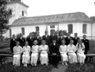 Konfirmander, 7 flickor, 10 pojkar och pastor Thorman.
Tysslinge kyrka i bakgrunden.