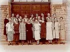 Norra Folkskolan, Högre Folkskolan eller Fortsättningsskolan, 20 skolflickor med lärare, sal 36, klass 3A. Skolbyggnad i bakgrunden.
Eva Ingvaldsson