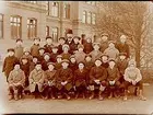 Västra skolan, 32 skolpojkar med lärare, sal 2.
Skolbyggnad i bakgrunden.
J. Norelius