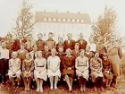 Almby skola, skolbyggnaden i bakgrunden.
25 skolbarn med lärare Åke Eriksson.