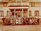 Lindbacka gård, tvåvånings bostadshus med balkong och veranda, förstuga och frontespis. Familjegrupp 39 personer framför huset.
Gustaf Petterssons 60 årsdag.