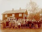 Tvåvånings klubbhus.
Medlemmar med 15 skolungdomar framför klubbhuset.
Örebro golfklubb.