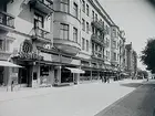 Stenhus i fem våningar med fasad i gulgrå grovputs. Byggnaden har en serie burspråk och dekorativa balkonger samt en enkel putsdekor. Bottenvåningen uppslagen av butiksfasad Hotell Storgården, Fredsgatan 11.
Huset kallades i folkmun för de 100 jungfruarnas palats, pga det var osedvanligt många jungfruar/hembiträden som bodde och arbetade i fastigheten.