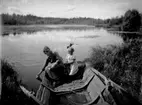 Två flickor i en roddbåt plockar näckrosor i Marksjön.
Märta och Ingrid Lindskog.