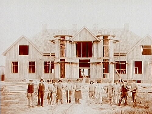 Sköllersta Tingshus.
Tingshuset under byggnad.
12 byggnadsarbetare framför byggnaden.