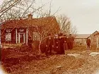 En och en halvvånings parstuga och ekonomibyggnader. Grupp, 9 personer.
Handlare Gustaf Mellander