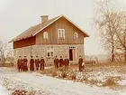 Envånings bostadshus, grupp 10 personer framför huset.
A.T. Södergren