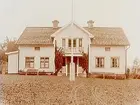 En och en halvvånings bostadshus med frontespis, förstebro och stolpbalkong och förstuga.
Grosshandlare P. Pehrman