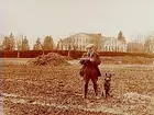 Älgskogens gård, en man och hans hund vid en dikesbrunn.
En och en halvvånings bostadshus med frontespis i bakgrunden.
Jordbrukskonsulent H. Flodkvist, Örebro.