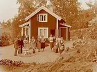 Sommarstugan, grupp 13 personer framför stugan.
Sam Lindskogs familjebild.