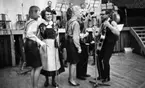 Pensionärspop 2 mars 1966

Inger Öst, Anna Öst, Bernt Öst och Gnesta-Kalle med orkester. Inger och Anna Öst står framför en mikrofon. Anna Öst bär folkdräkt. Till höger om dem står en kvinna samt Bernt Öst med gitarr vid en annan mikrofon. Mellan dem står ytterligare en herre med gitar. Han är delvis skymd. Uppe på estraden sitter tre herrar.