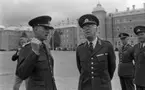 Kungen 13 28 augusti 1967

Kung Gustav VI Adolf besöker Örebro Livregementes Grenadjärer i Grenadjärsstaden. Ett antal män står uppställlda på regementsgården klädda i militäruniformer liksom kungen. Den sistnämnde står och samtalar med en general. Två andra militärer står till höger. Till vänster i bakgrunden syns en fotograf.