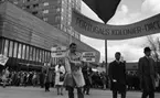 Första maj demonstration 2 maj 1967

En man klädd i vit rock kommer gående i ett första-majtåg utanför varuhuset Krämaren i Örebro med en banderoll med texten: 