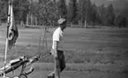 Grybe golf, Gustavsvik 17 juni 1967

En golfspelare kommer gående på golfbanan och drar sin golbag efter sig. Han är klädd i ljusrandig keps, vit tröja och ljusa byxor.