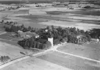 Flygfoto över Ekeby, kyrkan och bostadshus.