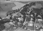 Flygfoto över Sköllersta, kyrkan och bostadshus.