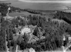 Flygfoto över Skagershults kyrka, Hasselfors.
Bilden tagen för vykort.
Förlag: Lundbergs, Hasselfors.