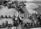 Flygfoto över Snavlunda, kyrkan och bostadshus.