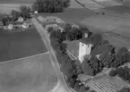 Flygfoto över Stora Mellösa, kyrkan och bostadshus.