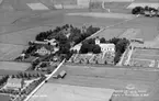 Flygfoto över Hallsberg, kyrkan och bostadshus.
Bilden tagen för vykort.