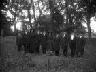 Begravning, grupp tio personer vid gravplatsen.