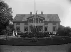 Bostadshus, fyra personer framför huset.