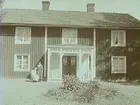 24 juni 1934. Två damer framför ett hus