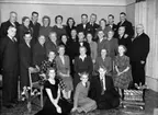Rumsinteriör, gruppbild. 
Fotografiet föreställer fru Anna Larsson (född Nors). Troligen taget vid hennes 70 års dag 14 januari 1951.