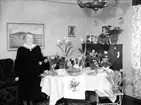 Rumsinteriör, en kvinna.
Fotografiet föreställer fru Anna Larsson (född Nors). Troligen taget vid hennes 70 års dag 14 januari 1951.