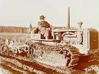 En man, en traktor av märket Caterpillar diesel.
(JUF) Örebrobygdens JUF-avd.