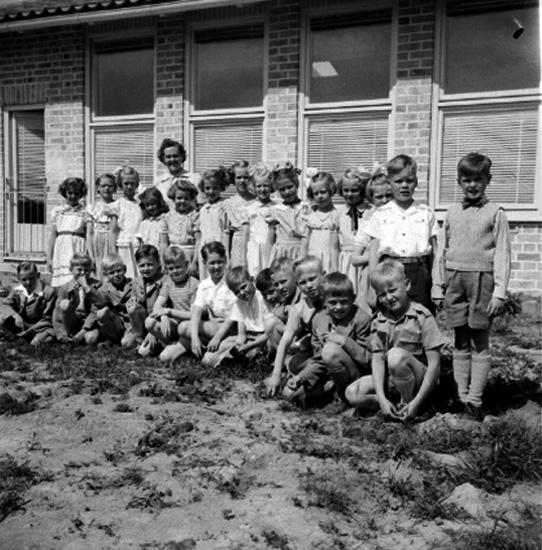 Rostaskolan, skolbarn med lärare fröken Olsson på skolgården.
Skolbyggnad i bakgrunden.
Från början hette skolan Rostaskolan, omkring 1955 bytte den namn till Hagaskolan och sen till Stjärnhusskolan. År 2019 är den förskola och har bytt namn igen.