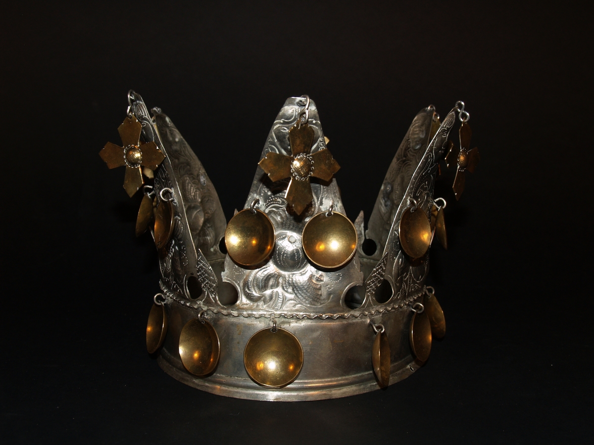 Det er ei heilrend krone, det vil seie at den er klipt/sagd ut av ei metallplate og lodda saman. Den har seks taggar og er ei open krone. Kvar tagg er dekorerte med blomemønster og i toppen er det eit ansikt, som kan tolkast som annankvar mann og kvinne. I kvar tagg er det eit heng med eit kors i messing, det er også to blad i messing halvvegs opp på kvar tagg og 12 messingblad langs med ein bøljekant nede. Under blada er det ein glatt kant utan dekor, den glatte kanten avsluttast i to bølgjer. Denne glatte kanten er vanleg på kroner og her skal det vere eit band eller eit tøystykke. I ein avisartikkelen i avisa Samhold frå 1954 er krona vår avbilda med eit tøystykke rundt, og i tilvekstprotokollen er det ført inn at krona har eit raudt fløyelsband. Dette er seinare strøket over og tøystykket er dessverre borte.